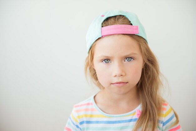 Petite fille positive dans des vêtements à la mode et une casquette