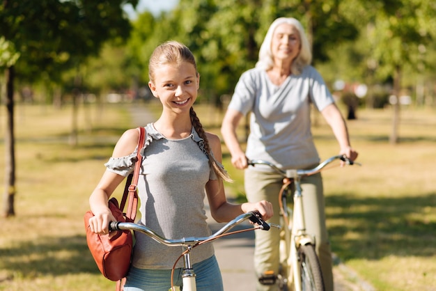 Petite-fille positive et sa grand-mère dans le parc à bicyclette