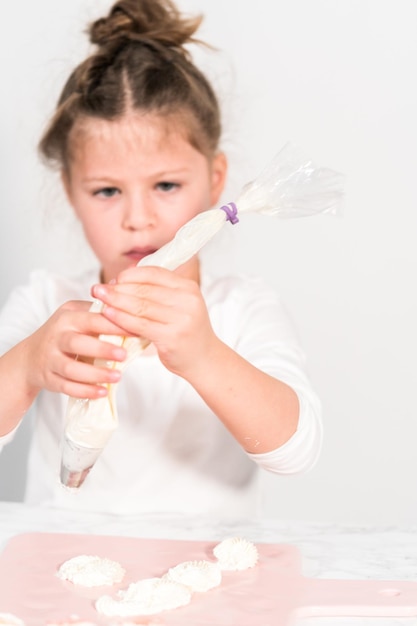 Petite fille pratiquant la tuyauterie glaçage au beurre italien