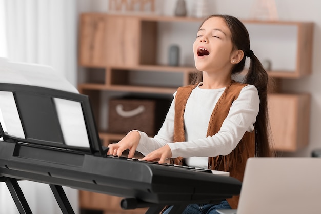 Petite fille prenant des cours de musique en ligne à la maison