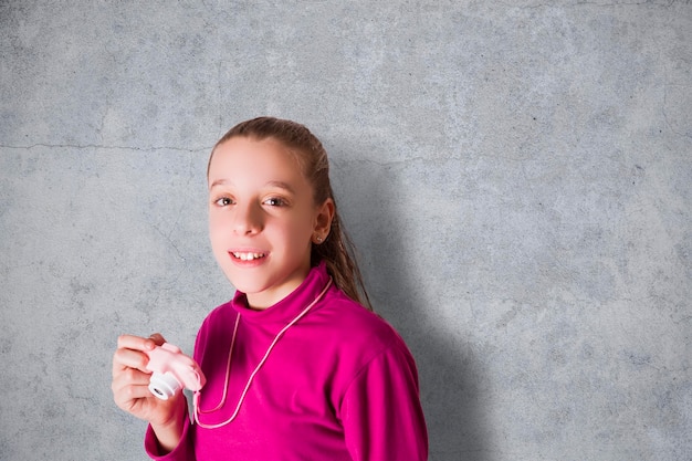 Petite fille prenant une photo à l'aide d'un appareil photo jouet