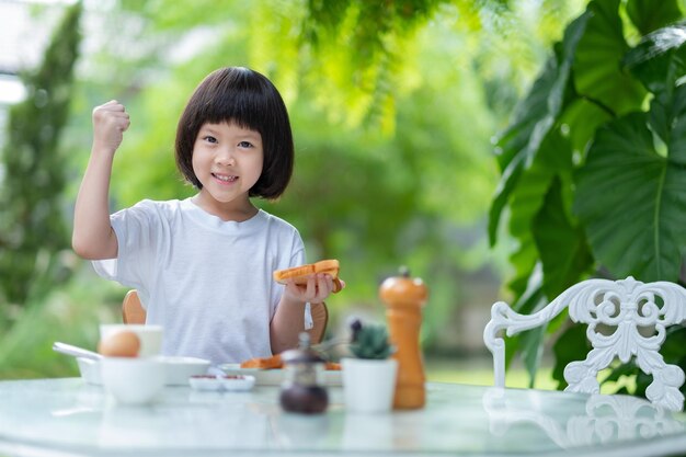 Petite fille prend son petit déjeuner heureux