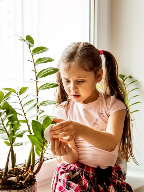 Petite fille, prendre soin des plantes d'intérieur à la maison