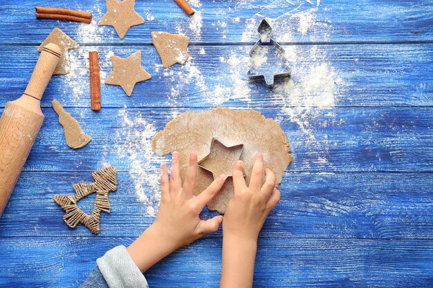 Petite fille préparant des biscuits de Noël à table