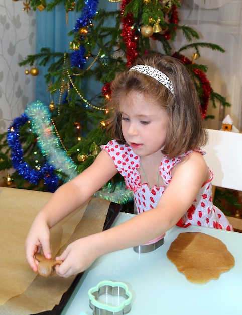 Petite fille préparant des biscuits de Noël