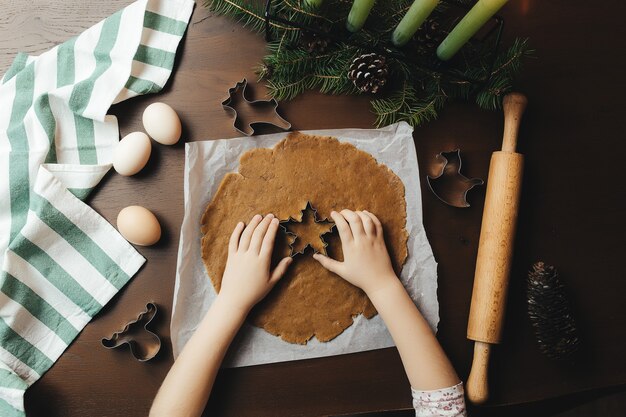 La petite fille prépare des biscuits de pain d'épice de Noël. photo de haute qualité