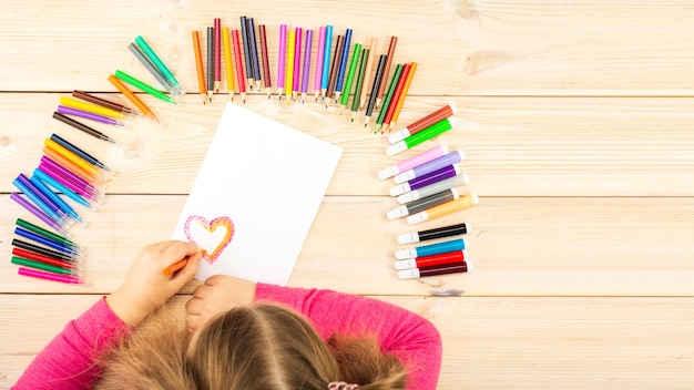 Petite fille prépare des cartes avec des coeurs pour la Saint-Valentin