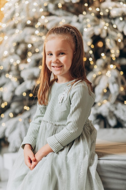 Petite fille près de l'arbre de Noël