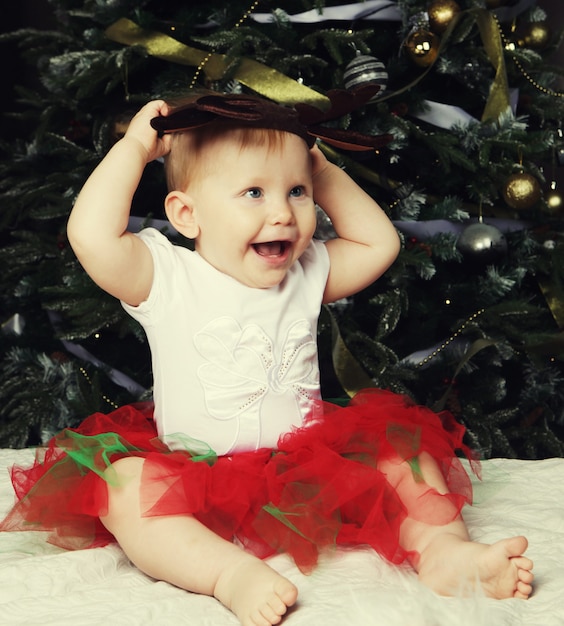 Petite fille près de sapin de Noël de décoration.