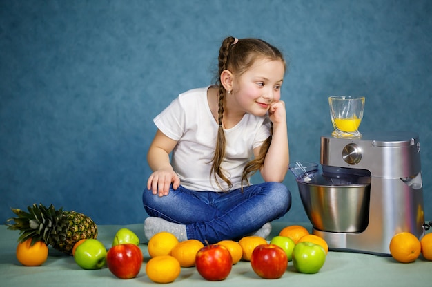 Une petite fille a pressé du jus de fruits frais de pommes et d'orange. Vitamines et alimentation saine pour les enfants.