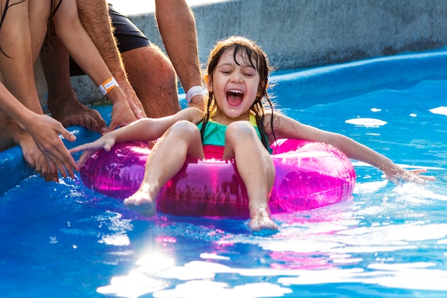 Petite fille profitant de la piscine sur un flotteur d&#39;été