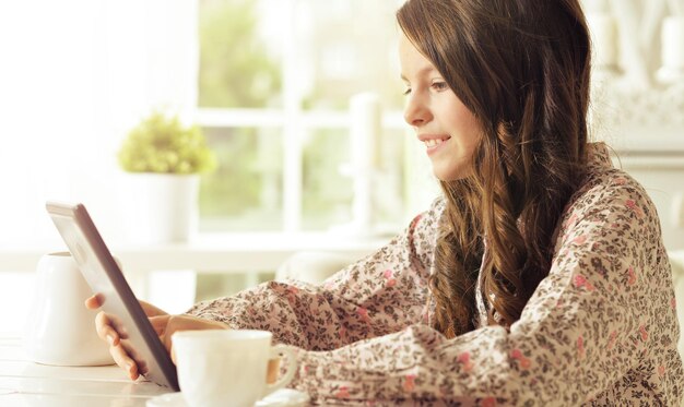 Petite fille en pyjama à l'aide de tablette numérique