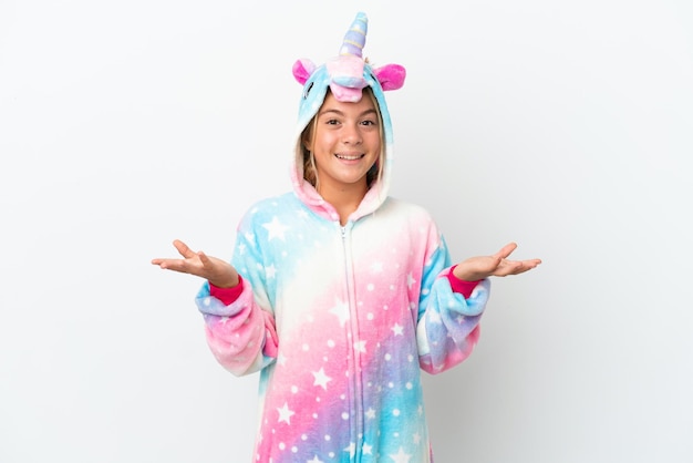 Petite fille avec un pyjama de licorne isolé sur fond blanc avec une expression faciale choquée