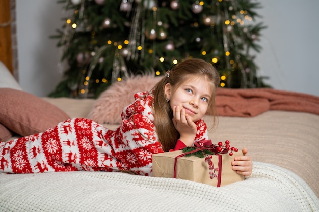 Petite fille en pyjama matin trouvé présent du Père Noël sous l'arbre