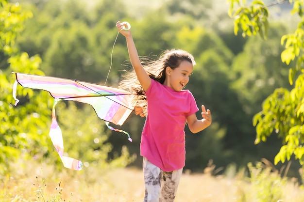 petite fille qui court en plein air avec un cerf-volant