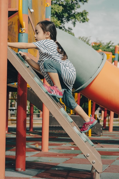 Photo une petite fille qui joue dans l'aire de jeux.