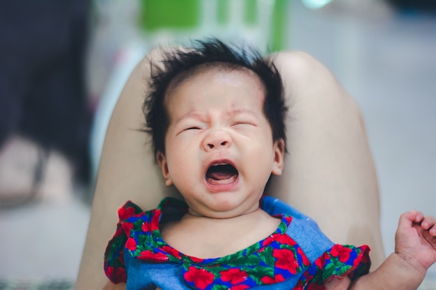 Petite fille qui pleure affamée pour sa mère sur le genou de tante