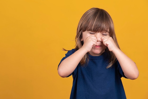 Petite fille qui pleure sur fond jaune