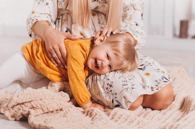 La petite fille qui rit se trouve sur les genoux de sa mère