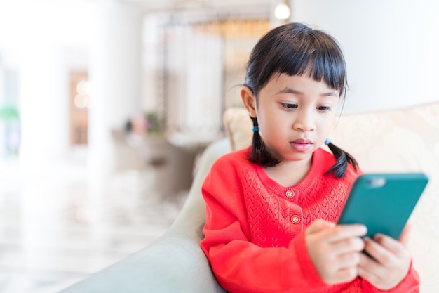 Petite fille qui utilise un téléphone portable