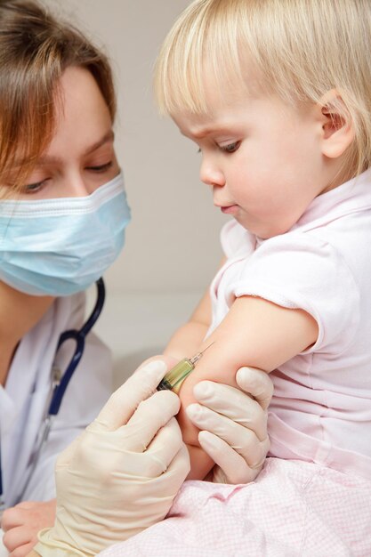 Photo une petite fille reçoit une injection.