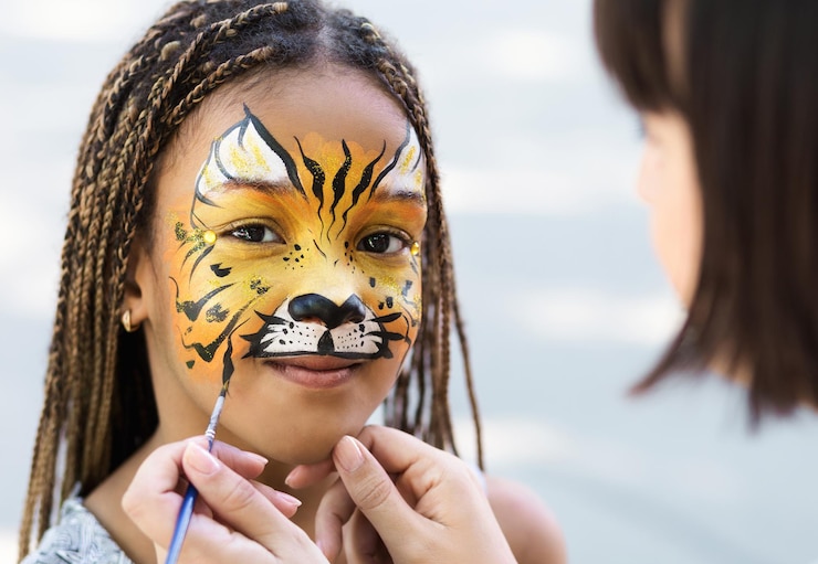 Photo une petite fille reçoit son visage peint par un peintre de visage