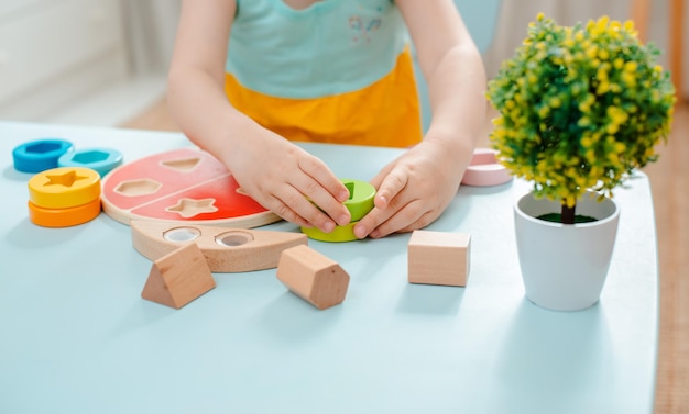 Une petite fille récupère un trieur multicolore en bois Jouets sûrs pour enfants en bois naturel