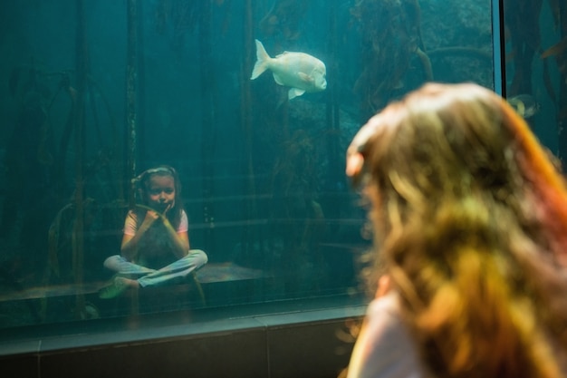 Petite fille en regardant un aquarium