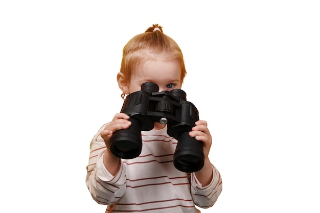 petite fille regardant dans des jumelles isolées sur un fond blanc