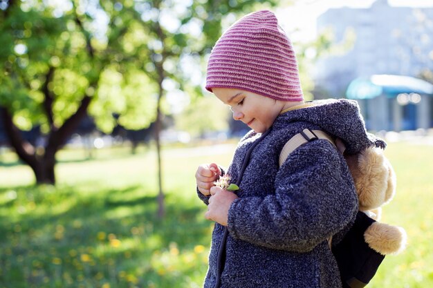 Petite fille regardant une fleur dans les mains