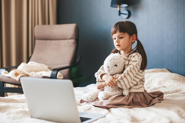 Petite fille regardant l'ordinateur portable