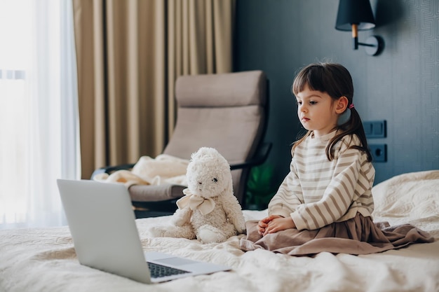 Petite fille regardant l'ordinateur portable