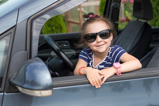 Photo une petite fille regardant par la fenêtre d'une voiture.