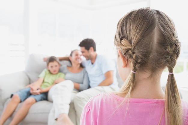 Petite fille en regardant sa famille sur le canapé