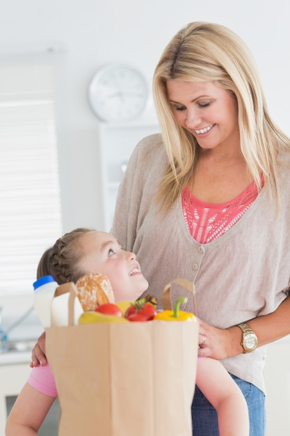 Petite fille en regardant sa mère après l&#39;épicerie