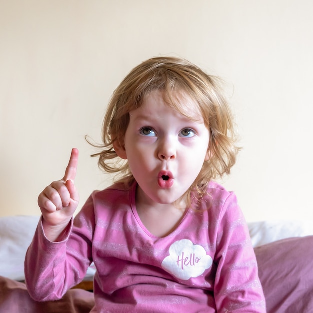 Une petite fille regarde la caméra et grimace.