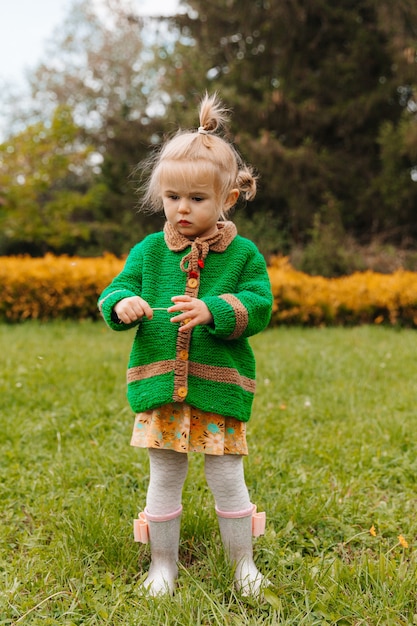 La petite fille regarde dans la caméra. portrait sérieux d'un petit enfant sur fond de nature.