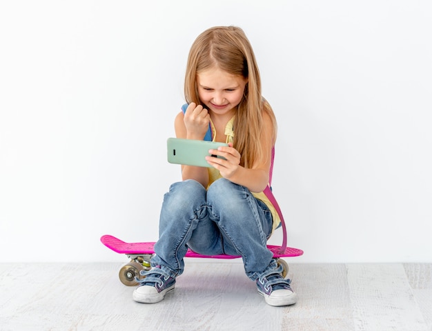 Petite fille, regarder téléphone, séance, sur, patin