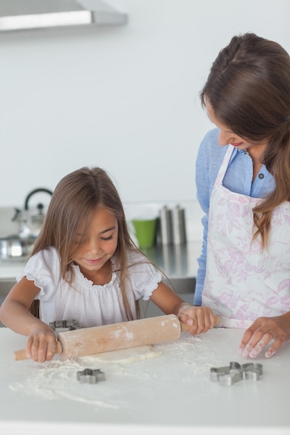 Petite fille répand une pâte avec un spin roulant