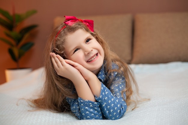 Petite fille reposant sur le lit dans la chambre