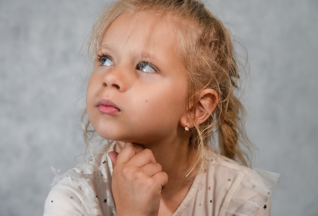 Petite fille rêve et lève les yeux, portrait.