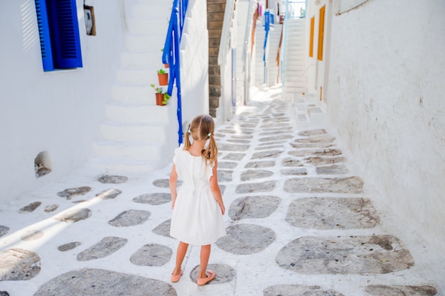 Petite fille en robe blanche dans les vieilles rues de Mykonos.