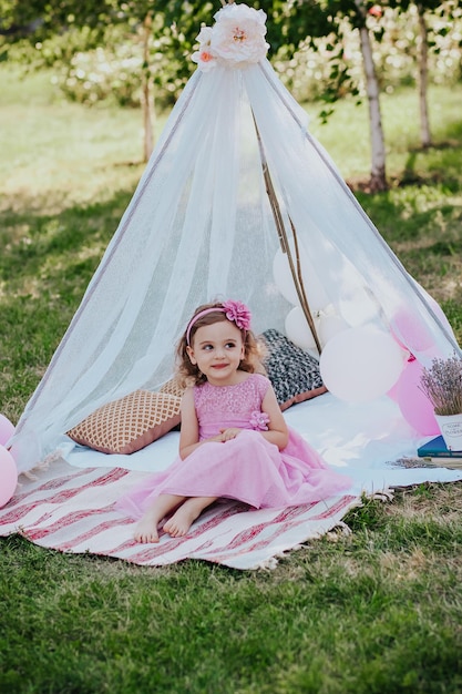 petite fille en robe rose s'amusant dans le jardin