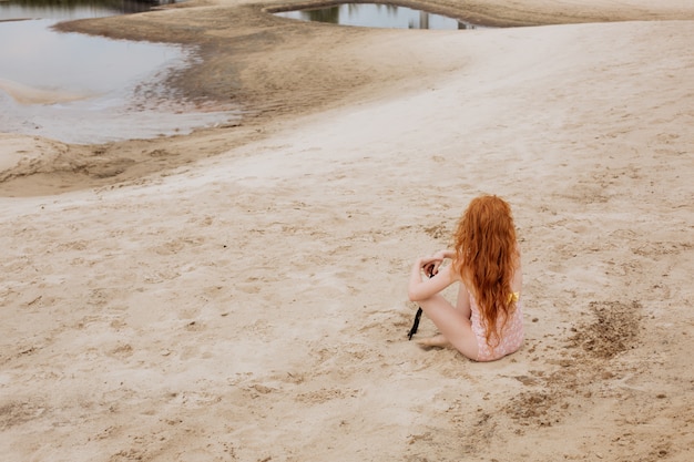 Petite fille rousse jouant sur une plage