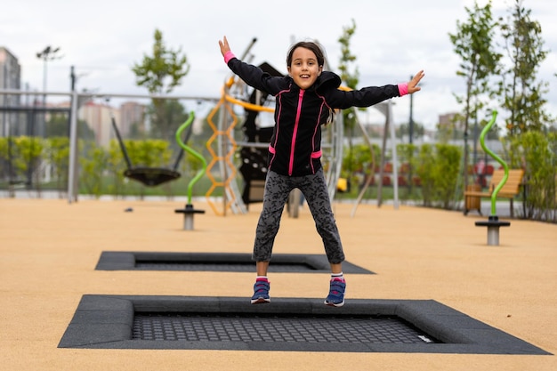 Petite fille s'amusant à jouer sur le terrain de sport