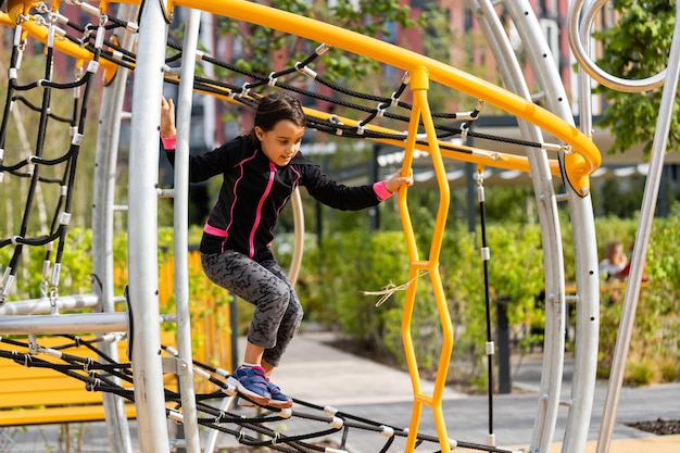 Petite fille s'amusant à jouer sur le terrain de sport