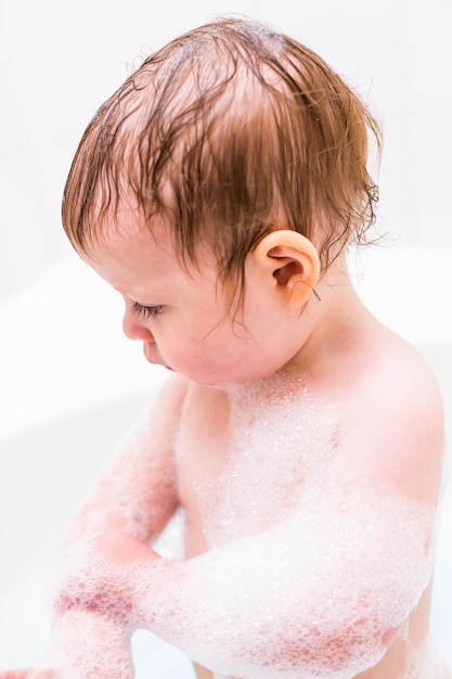 Petite fille s'amusant pendant l'heure du bain.