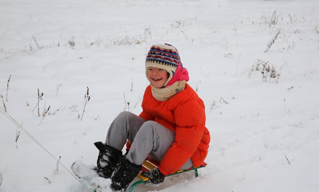 Petite fille s'amuse en hiver avec un traîneau