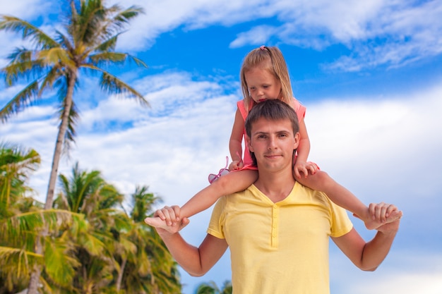 Petite fille s'amuser avec son père à la plage tropicale