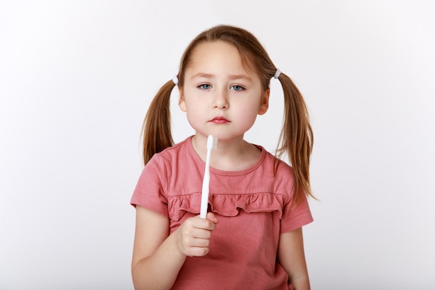 Petite fille s'ennuie d'avoir à se brosser les dents